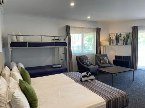 a bedroom with a bunk bed and a chair at The Kimberley Grande Resort in Kununurra
