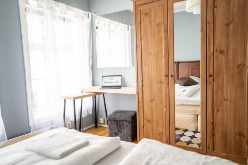 Schlafzimmer mit einem Bett, einem Schreibtisch und einem Spiegel in der Unterkunft The Green House of Stavanger BnB 14 -Central, Sauna and Airport Shuttle in Stavanger