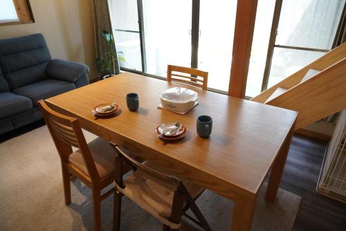 a wooden table with two cups and a bowl on it at 桜香楽　宮津町家　Sakara Miyazu-Machiya in Miyazu