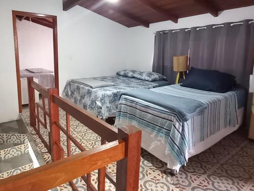 a bedroom with two beds and a mirror at Casa de Temporada Praia do Moçambique in Florianópolis