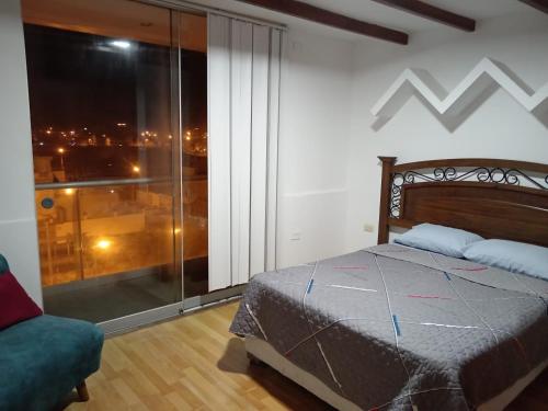 a bedroom with a bed and a large glass window at EDIFICIO MARIA KIAN in San Bartolo
