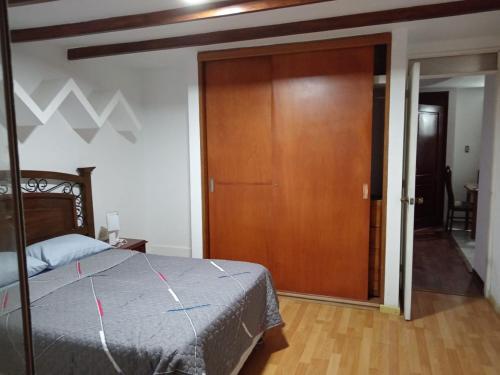 a bedroom with a bed and a wooden door at EDIFICIO MARIA KIAN in San Bartolo
