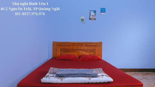 - un lit avec une couverture rouge et des oreillers rouges dans l'établissement Nhà nghỉ Bình Yên - Miễn phí khăn lạnh, nước suối. Giá chỉ 40k/1h đầu (giờ sau +10k), à Quảng Ngãi