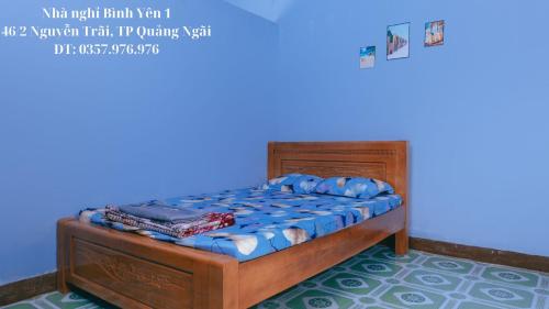 a bedroom with a bed in a blue room at Nhà nghỉ Bình Yên - Miễn phí khăn lạnh, nước suối. Giá chỉ 40k/1h đầu (giờ sau +10k) in Quảng Ngãi