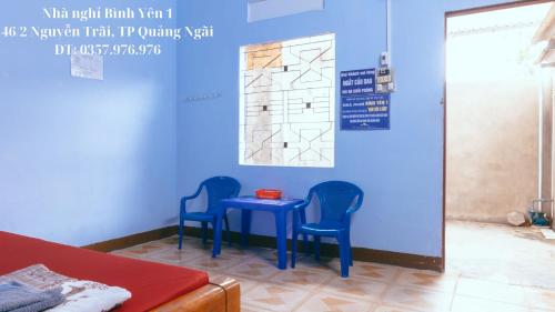 Zimmer mit zwei blauen Stühlen und einem blauen Tisch in der Unterkunft Nhà nghỉ Bình Yên - Miễn phí khăn lạnh, nước suối. Giá chỉ 40k/1h đầu (giờ sau +10k) in Quảng Ngãi