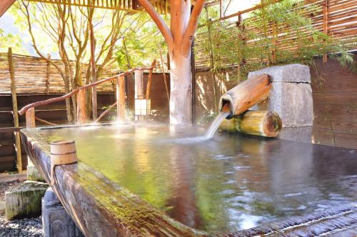 a water fountain with a tree in the middle at Shirakabe in Izu