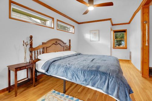 a bedroom with a bed and a table and windows at Beautiful Historic House in Central Longmont in Longmont