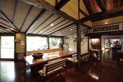 a dining room with a wooden table and chairs at Shirakabe in Izu