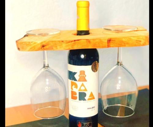 a bottle of wine on a wooden shelf with two glasses at Beachfront Cozy Apt in Gros Islet