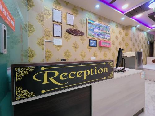 a reception desk with a sign on a wall at GULAB LODGE in Siliguri