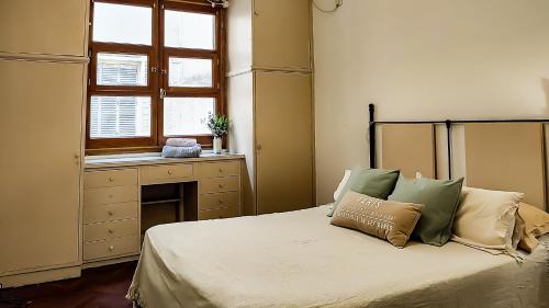 1 dormitorio con 1 cama, ventana y escritorio en Amplio y Hermoso con Hidromasaje en Buenos Aires