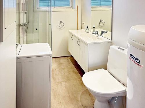 Baño blanco con aseo y lavamanos en Holiday home Hornnes, en Hornnes