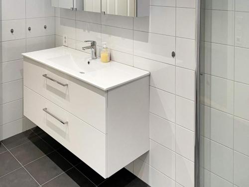 La salle de bains blanche est pourvue d'un lavabo et d'un miroir. dans l'établissement Holiday home Ålfoten, à Davik