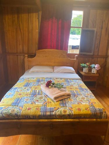 ein Bett mit einer bunten Decke darüber in der Unterkunft Chocotulipe Lodge & Spa in Mindo