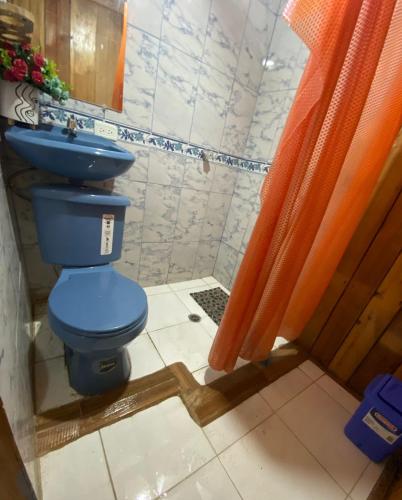 ein Badezimmer mit einem blauen WC und einer Dusche in der Unterkunft Chocotulipe Lodge & Spa in Mindo