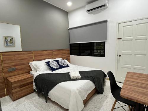 a bedroom with a bed and a window and a table at Traveller's stay for 10 pax in Ipoh