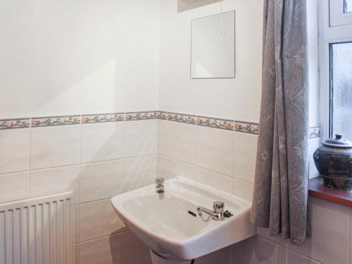 a white bathroom with a sink and a mirror at Pine Tree Cottage - Uk45925 in Ballater