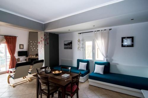 un soggiorno con divano blu e tavolo di Amazing Beachside Apartment With Panoramic Seaview a Paránimfoi