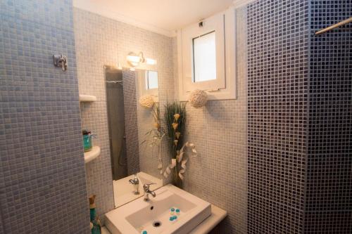 bagno con lavandino e specchio di Amazing Beachside Apartment With Panoramic Seaview a Paránimfoi