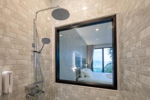 La salle de bains est pourvue d'une fenêtre et d'un lit. dans l'établissement Nature Vista Rawai, à Nai Harn Beach