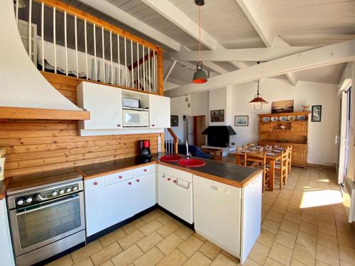 une cuisine avec des placards blancs et une salle à manger dans l'établissement Maison familiale à 400m de la plage avec terrasse de 100m², animaux admis, garage et jardin - FR-1-231-292, à Bretignolles-sur-Mer