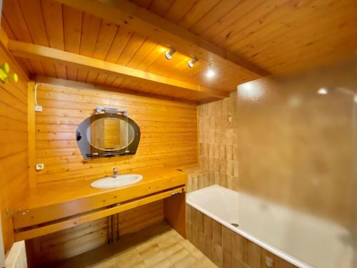 une salle de bain avec un lavabo, un miroir et une baignoire dans l'établissement Maison familiale à 400m de la plage avec terrasse de 100m², animaux admis, garage et jardin - FR-1-231-292, à Bretignolles-sur-Mer