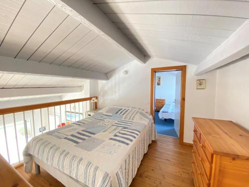 une chambre avec un lit et un parquet dans l'établissement Maison familiale à 400m de la plage avec terrasse de 100m², animaux admis, garage et jardin - FR-1-231-292, à Bretignolles-sur-Mer