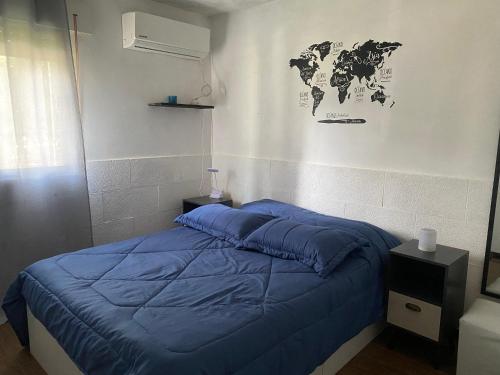 um quarto com uma cama azul e um mapa do mundo na parede em Lindo apto Mvd shopping puerto de buceo/pocitos em Montevidéu