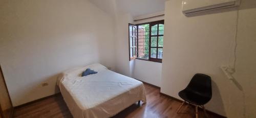 um pequeno quarto com uma cama e uma cadeira em LUCILU NUEVO POETA em Córdova