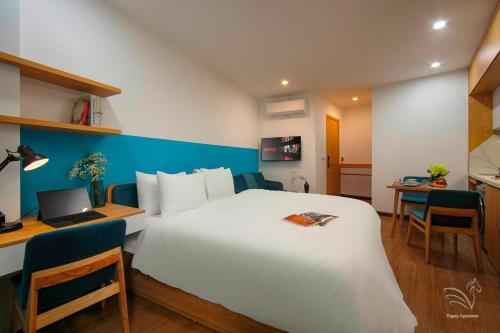 Schlafzimmer mit einem weißen Bett, einem Schreibtisch und einem Laptop in der Unterkunft Westlake Pearl Apartment & Hotel - By Pegasy Group in Hanoi