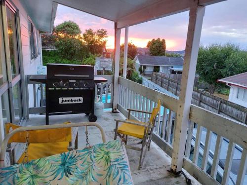a balcony with a grill and a table and chairs at Bed and Breakfast Happy Home Taupo Accommodation in Taupo