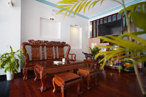 uma sala de estar com um banco de madeira e uma televisão em Kim Long Hotel Đà Lạt em Da Lat