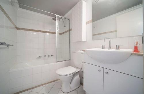 a white bathroom with a toilet and a sink at Entire Apartment in Surry Hills in Sydney