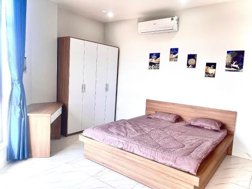 1 dormitorio con 1 cama con mantas moradas en Nguyễn Thư Homestay, en Chánh Long