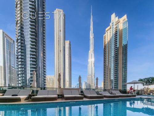 a swimming pool with chaise lounge chairs in a city at Act One Act Two by Emaar, Downtown Dubai in Dubai