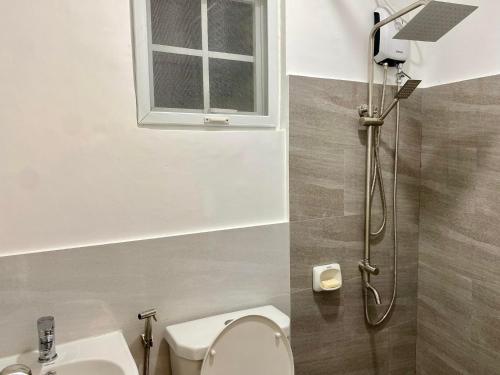 een badkamer met een douche, een toilet en een wastafel bij Casa Amelita Malolos 