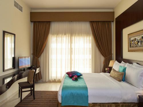 a hotel room with a large bed and a television at Arabian Dreams Hotel Apartments in Dubai
