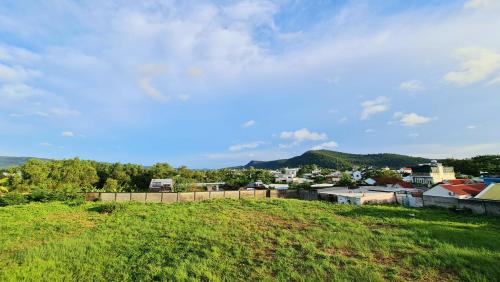 a view of a city from a grassy hill at TỊNH Retreat Phu Quoc in Phu Quoc