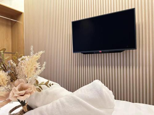 a flat screen tv hanging on a wall at Near Airport K Avenue Family Room in Donggongon