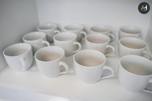 a group of white cups sitting on a shelf at Albelli Luxury Skyview in Košice