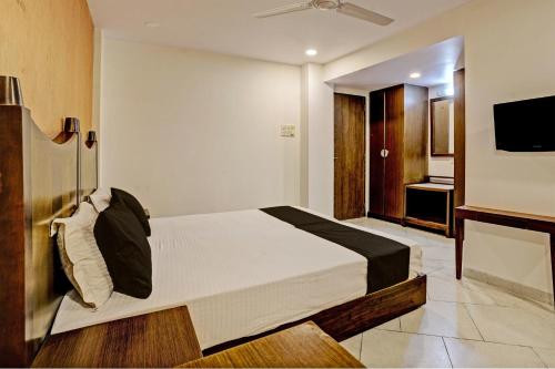 a bedroom with a large bed and a television at Super OYO Flagship Hotel Golden Nest in Saravli