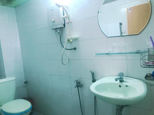 La salle de bains est pourvue d'un lavabo, d'un miroir et de toilettes. dans l'établissement Khách Sạn Xuân Quang, à Cần Thơ