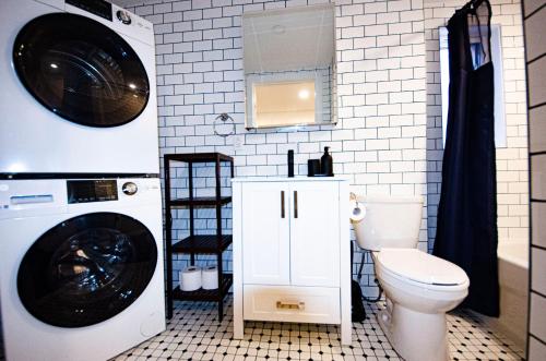 a bathroom with a washing machine and a toilet at Mila Downtown Home in Montreal