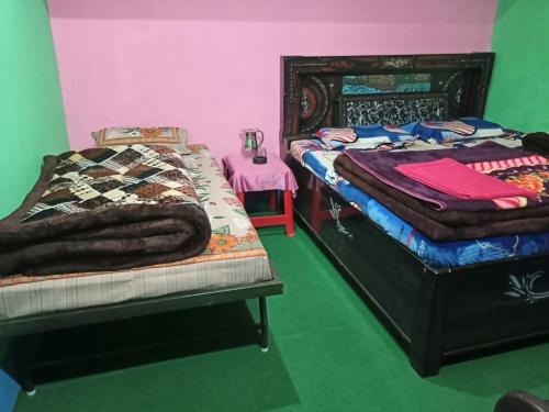 a bedroom with two twin beds and a table with a table at Holiday Home Chopta Tungnath in Ukhimath