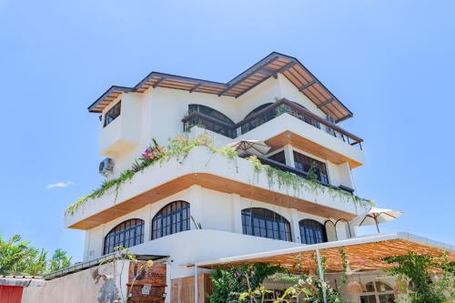 a tall white building with plants on it at THE SWAN BINGIN - 360 Ocean & Uluwatu Hills View in Bingin Beach in Uluwatu
