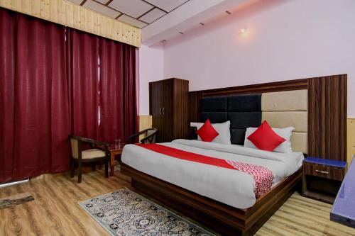 a bedroom with a large bed with red pillows at OYO Hotel The Cloud Hills in McLeod Ganj