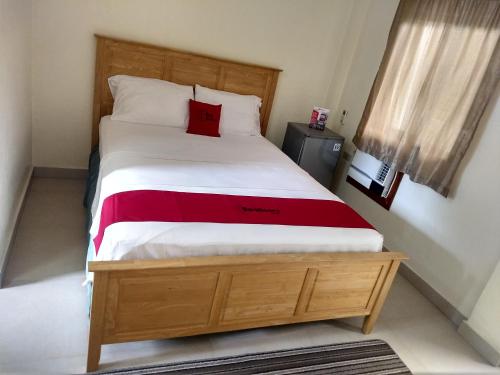 een slaapkamer met een bed met een rood kussen erop bij Gemini Hotel and Restaurant in Panglao