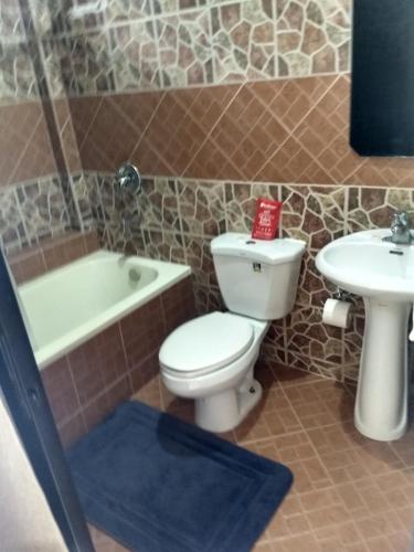 a bathroom with a toilet and a sink at Gemini Hotel and Restaurant in Panglao