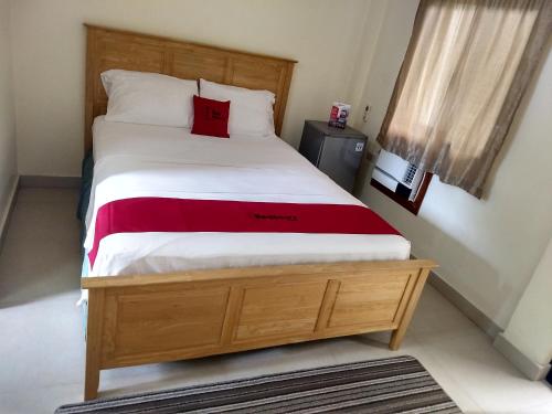 a bedroom with a large bed with a red pillow at Gemini Hotel and Restaurant in Panglao