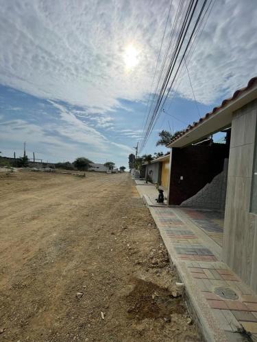 a dirt road next to a building with a sky at Casa Halley #6 con vista al mar in Playas
